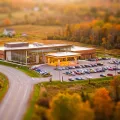 Tilt-shift miniature of a low modern casino building and its parking lot among autumn fields at the edge of a small city